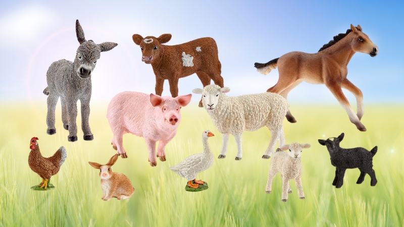 Schleich Farm World animal figures arranged in a grassy field, showing lifelike details of common farm animals
